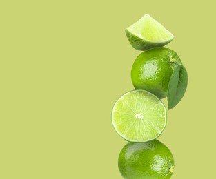 Image of Stacked fresh limes on light green background, space for text