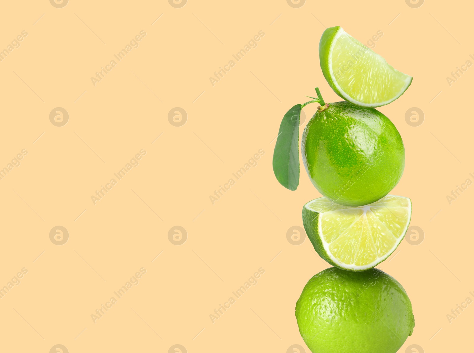 Image of Stacked fresh limes on beige background, space for text