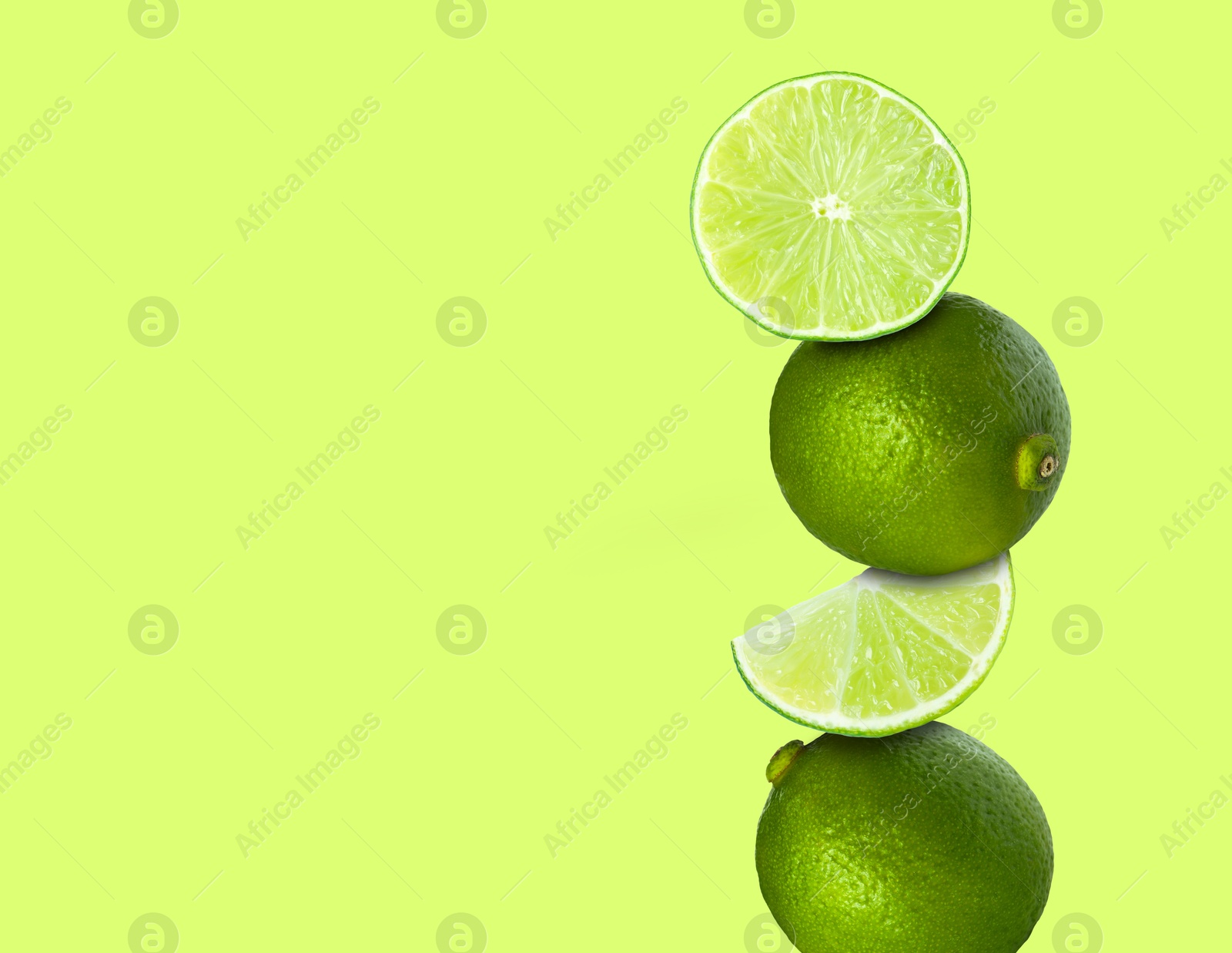 Image of Stacked fresh limes on light green background, space for text