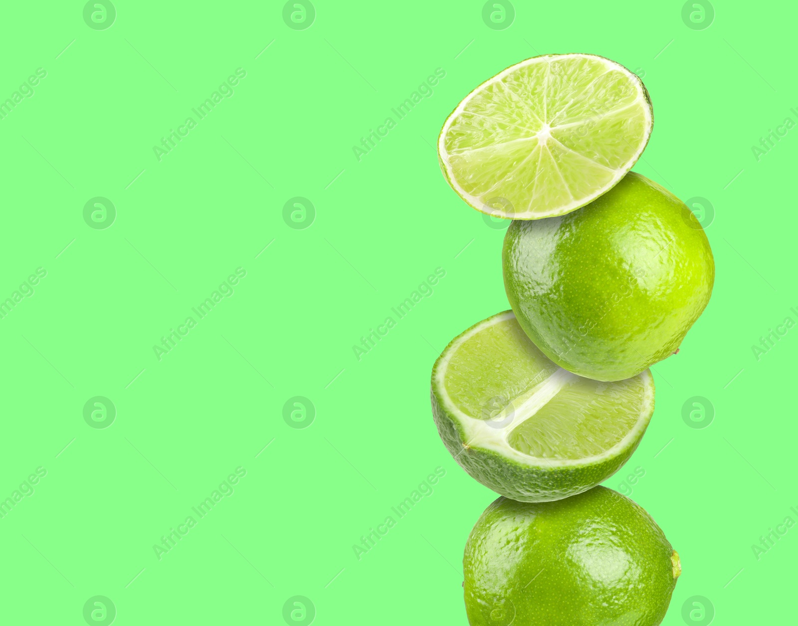 Image of Stacked fresh limes on green background, space for text