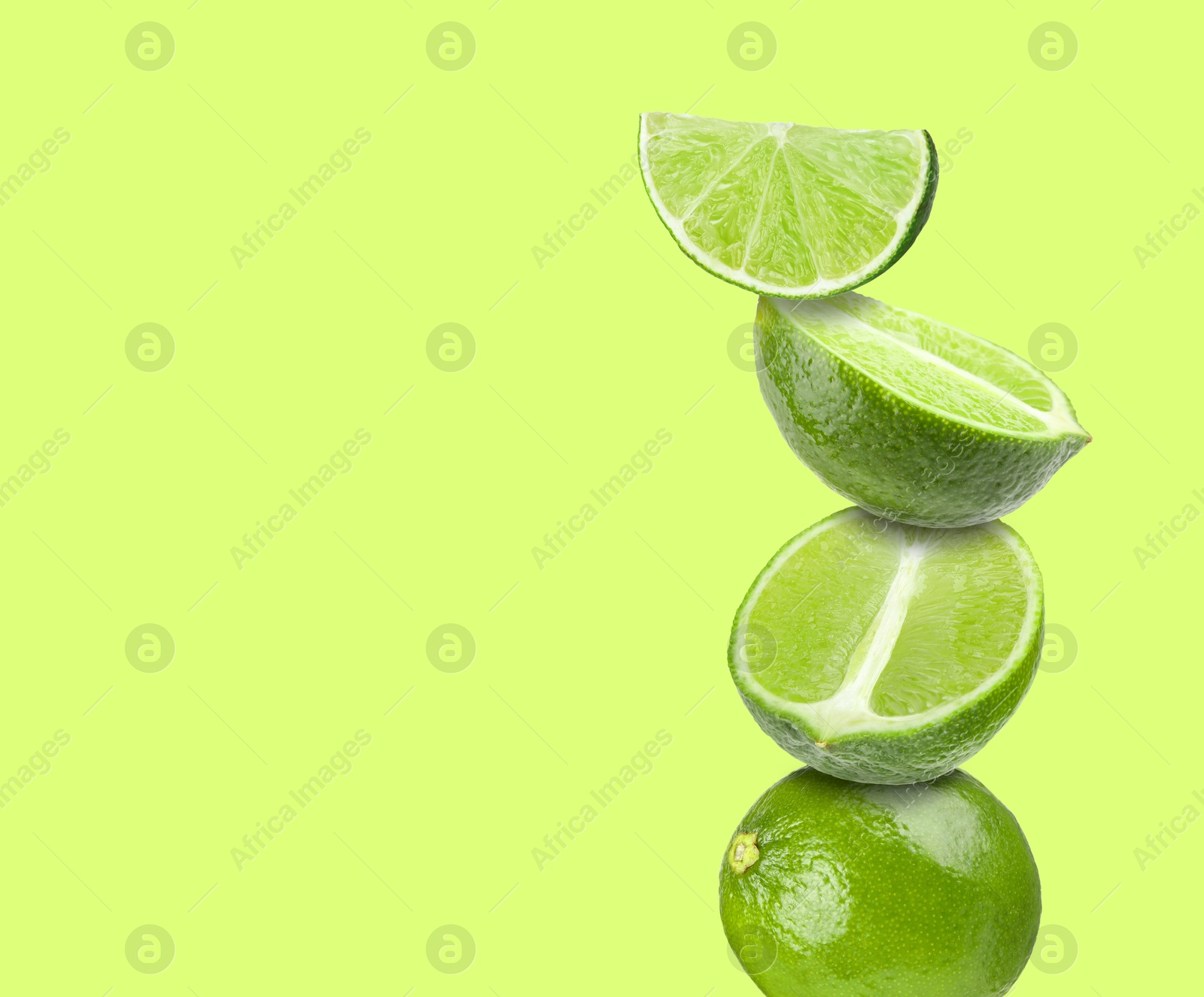 Image of Stacked fresh limes on light green background, space for text