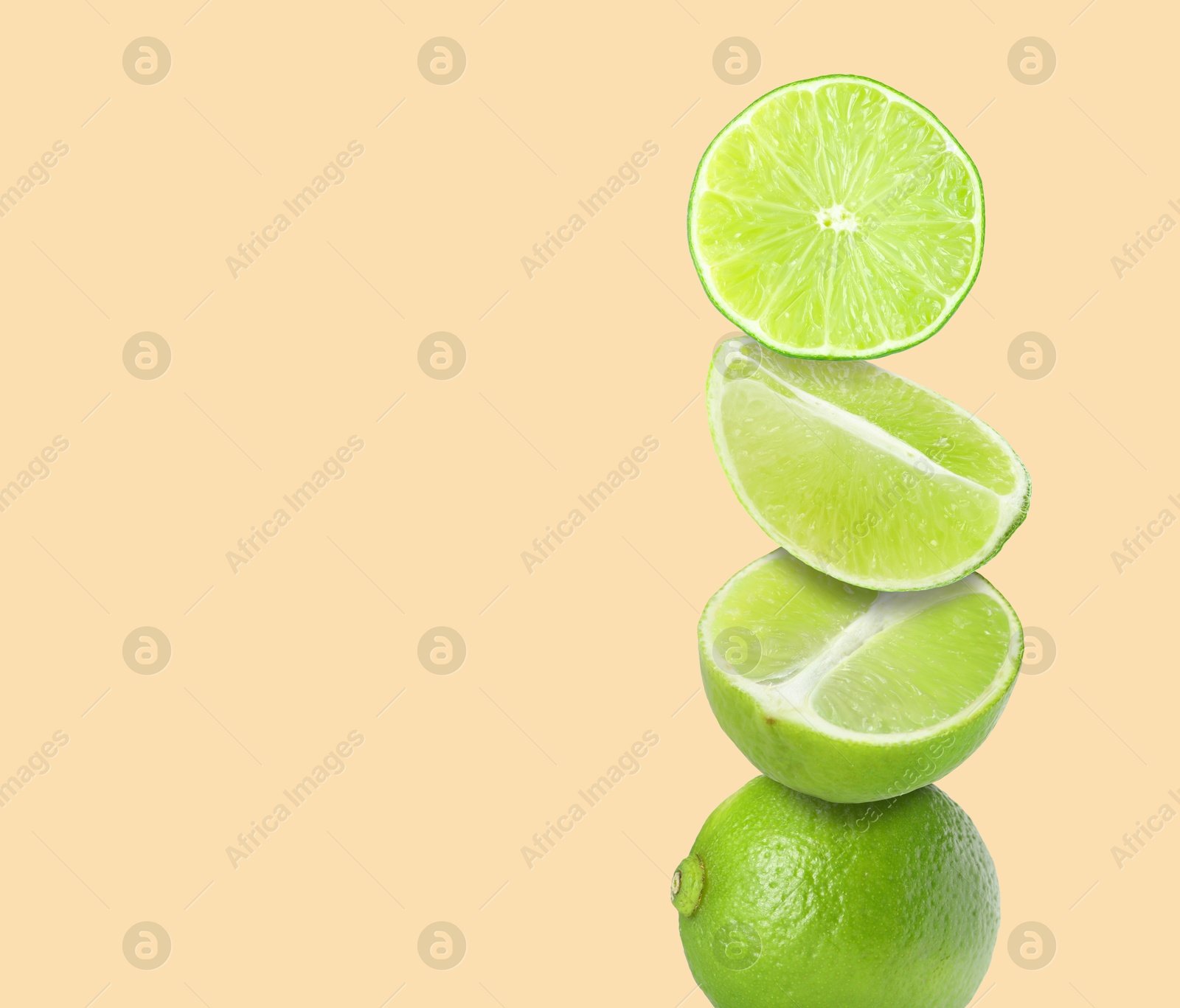 Image of Stacked fresh limes on pink beige background, space for text