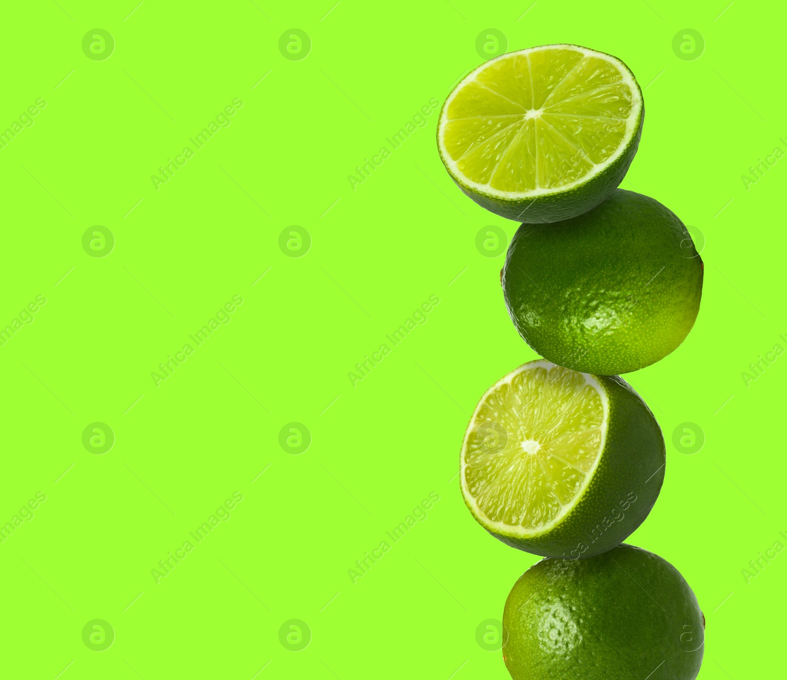 Image of Stacked fresh limes on bright green background, space for text