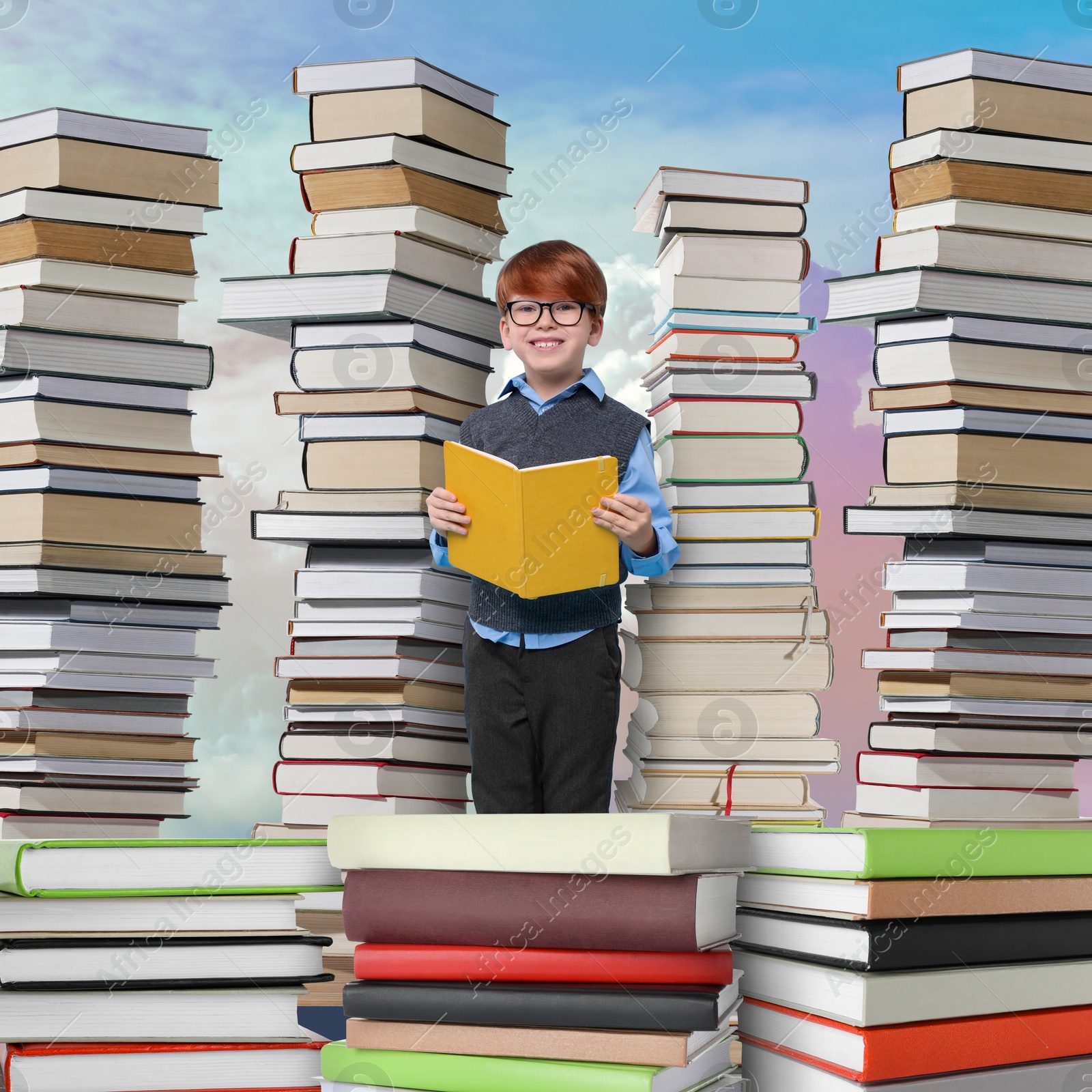 Image of Happy schoolboy among stacks of books in sky. Back to school