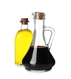 Photo of Balsamic vinegar in glass jug and oil isolated on white