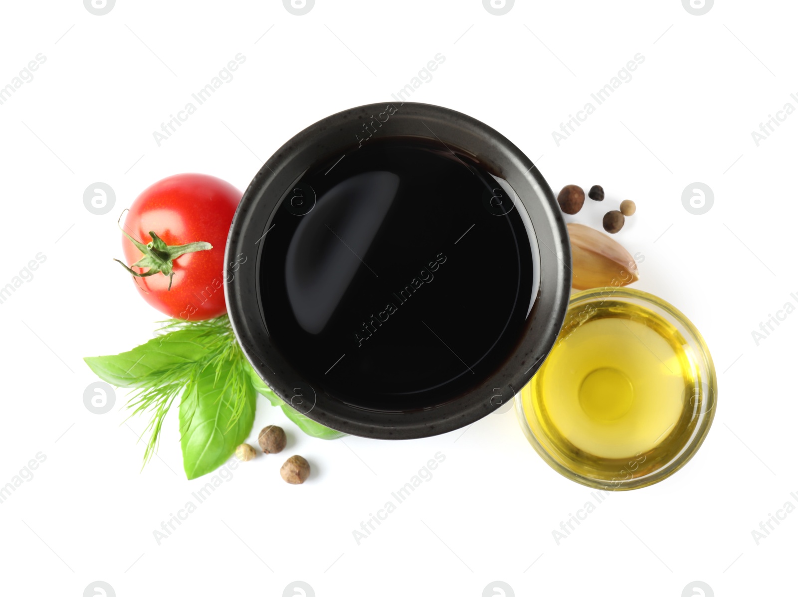 Photo of Balsamic vinegar in bowl, oil, herbs and spices isolated on white, top view