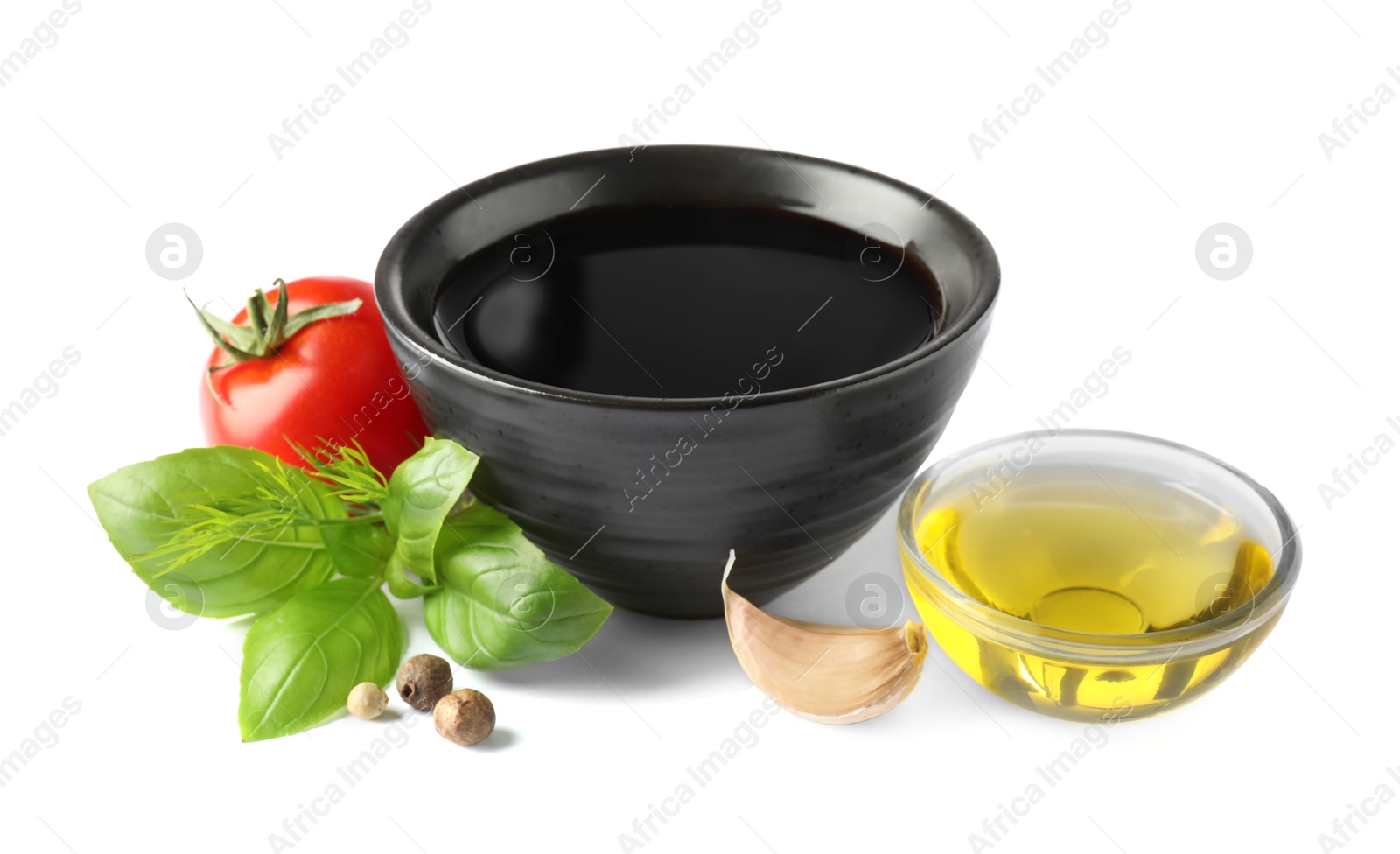 Photo of Balsamic vinegar in bowl, oil, herbs and spices isolated on white