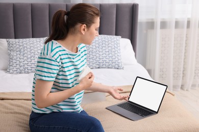 Photo of Sick woman having online consultation with doctor via laptop at home