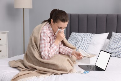 Photo of Sick woman having online consultation with doctor via laptop at home