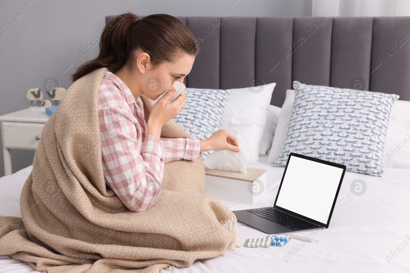 Photo of Sick woman having online consultation with doctor via laptop at home