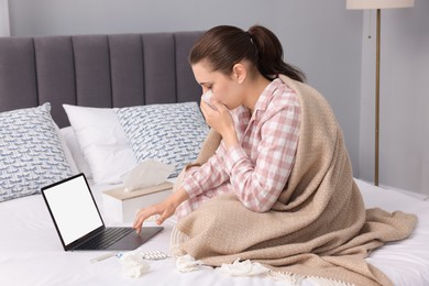 Sick woman having online consultation with doctor via laptop at home