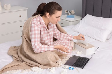 Sick woman having online consultation with doctor via laptop at home