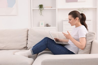 Sick woman having online consultation with doctor via laptop at home