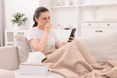 Photo of Sick woman having online consultation with doctor via smartphone at home