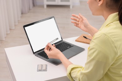 Photo of Sick woman with thermometer having online consultation with doctor via laptop at white table indoors, closeup