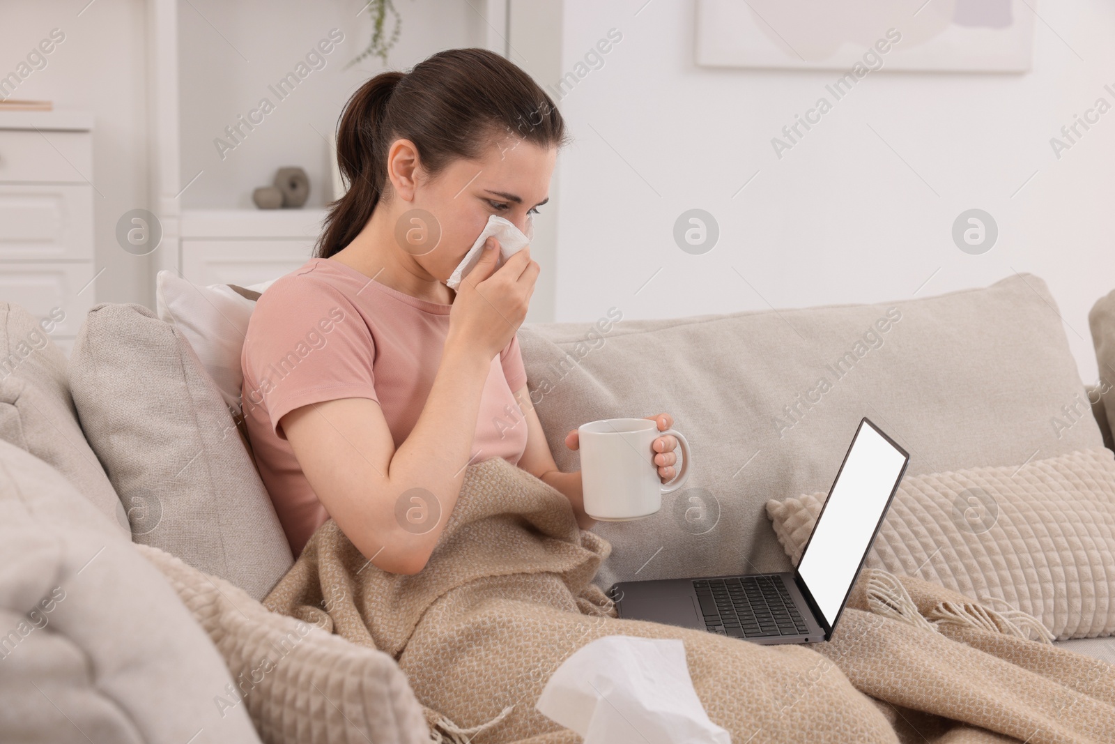 Photo of Sick woman having online consultation with doctor via laptop at home