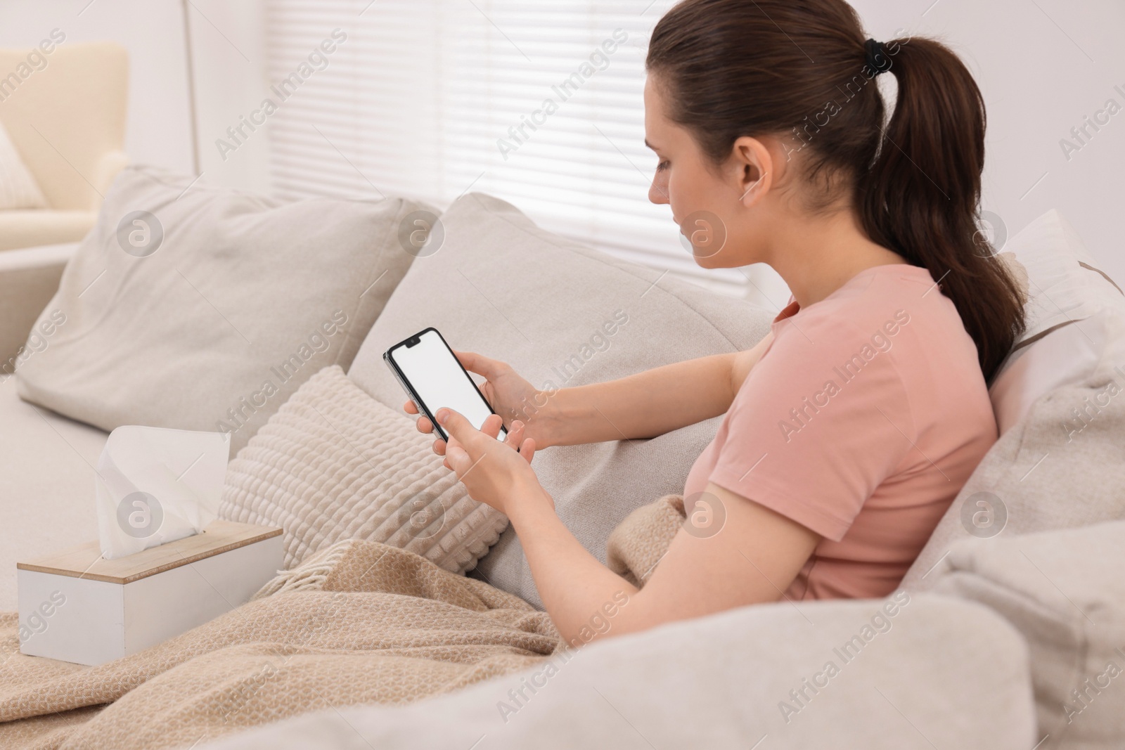 Photo of Sick woman having online consultation with doctor via smartphone at home