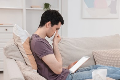 Sick man having online consultation with doctor via tablet at home