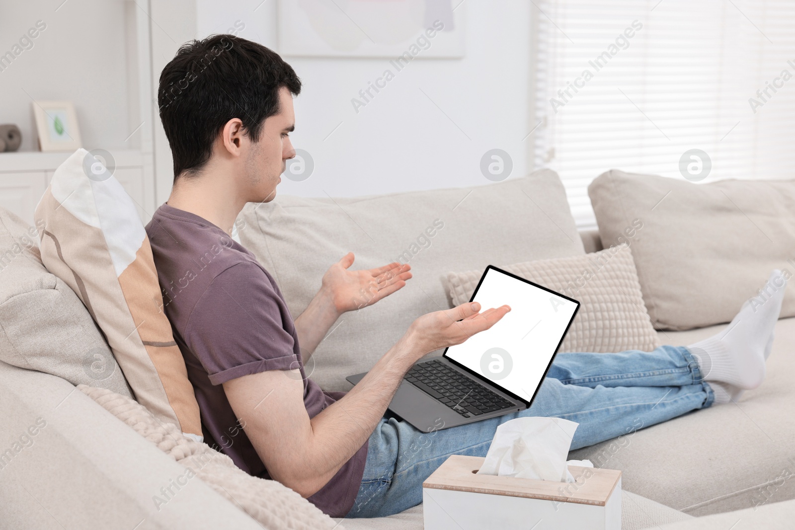 Photo of Sick man having online consultation with doctor via laptop at home