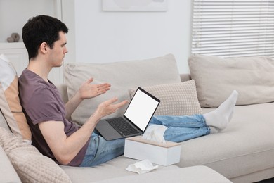 Photo of Sick man having online consultation with doctor via laptop at home