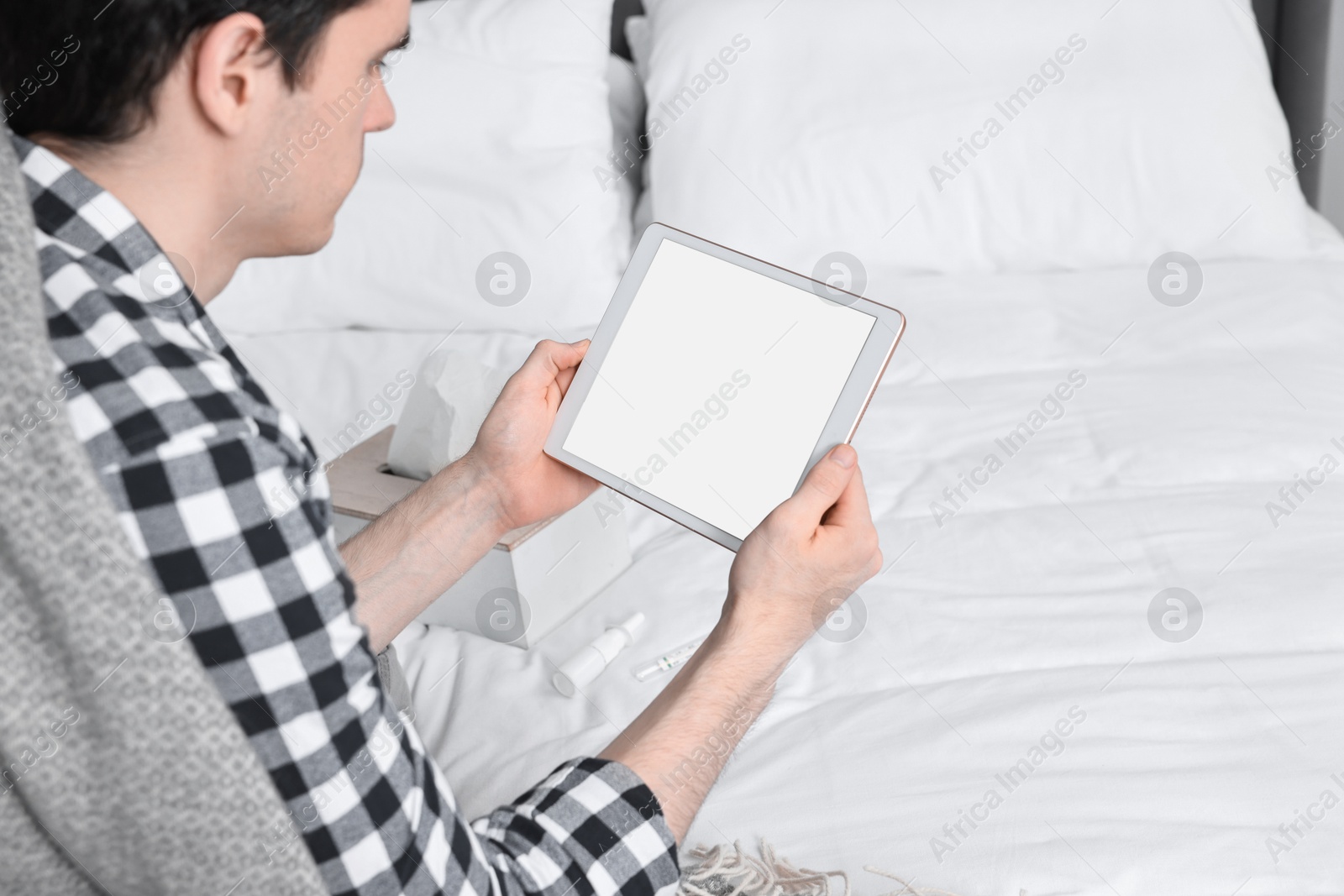 Photo of Sick man having online consultation with doctor via tablet at home