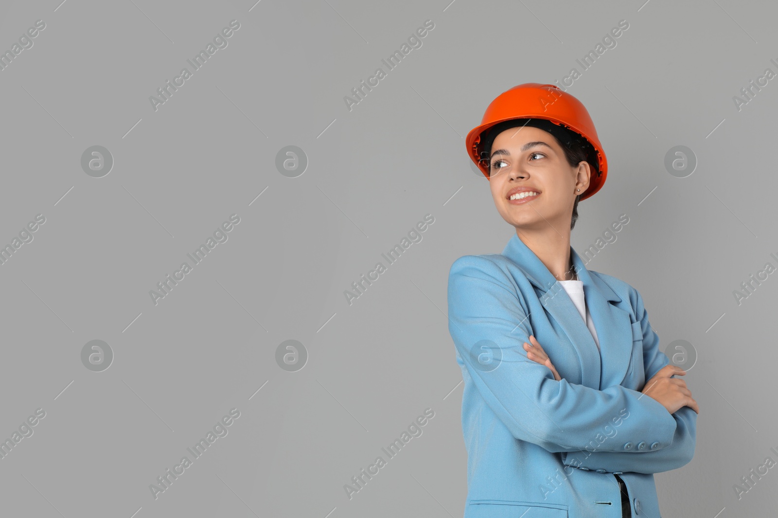 Photo of Engineer in hard hat on grey background, space for text