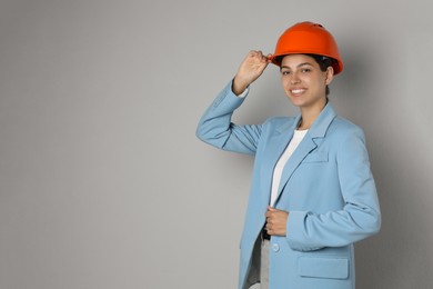 Photo of Engineer in hard hat on grey background, space for text