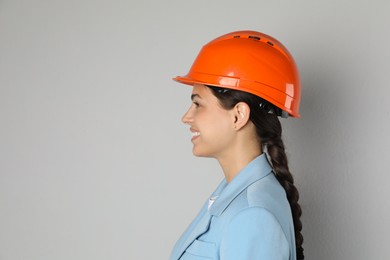 Photo of Engineer in hard hat on grey background