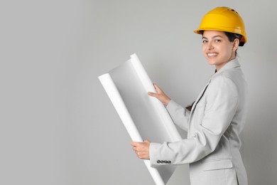 Photo of Engineer in hard hat with draft on grey background, space for text