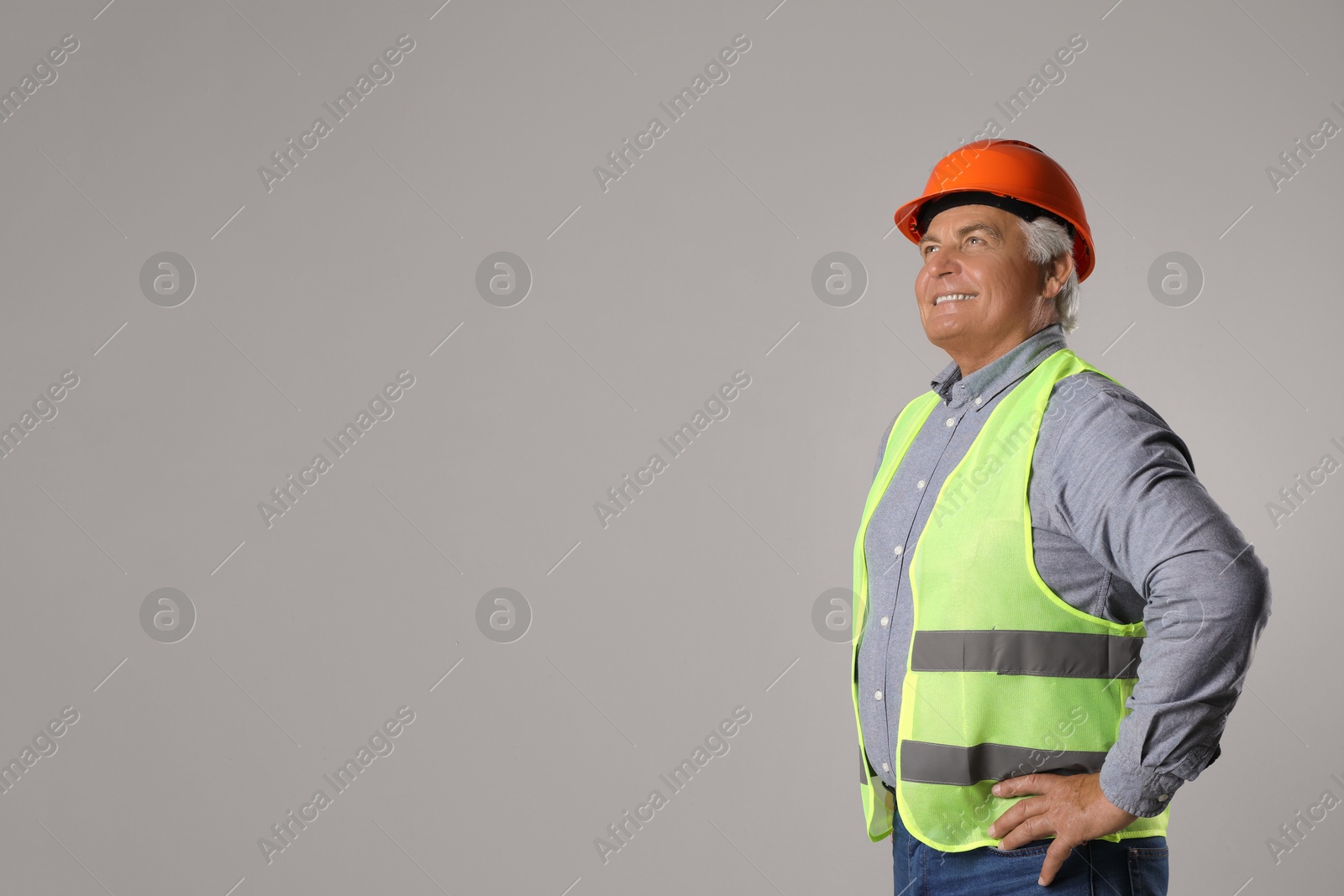 Photo of Engineer in hard hat on grey background, space for text