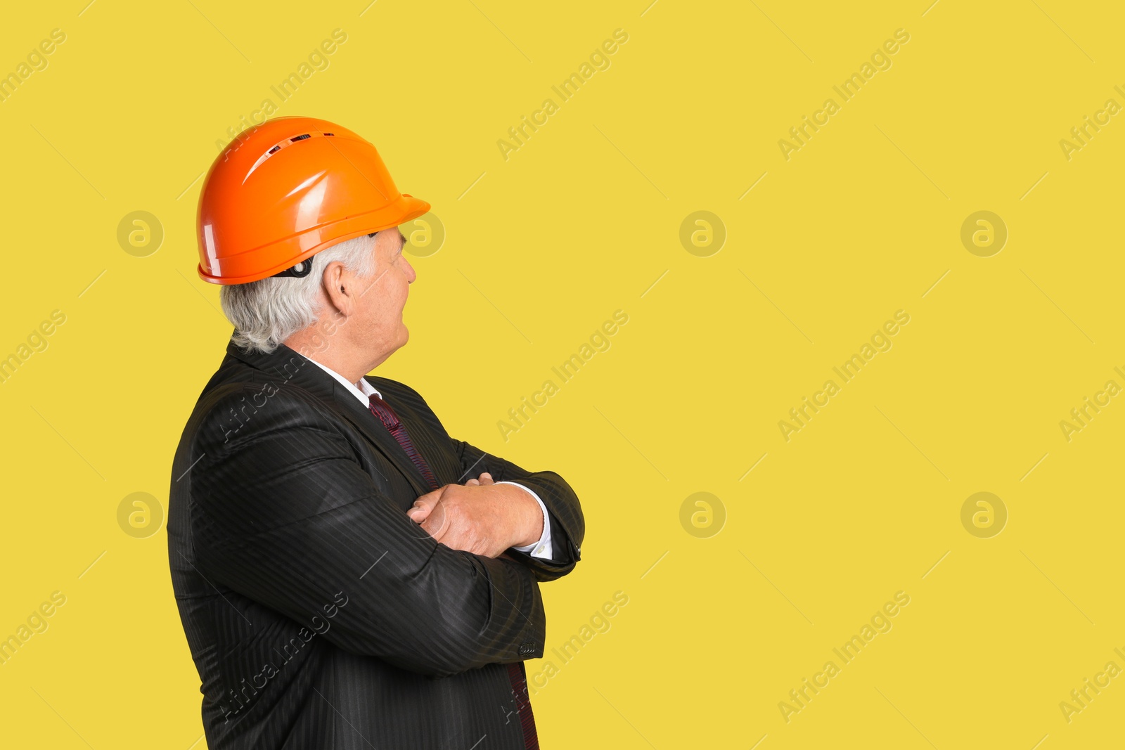 Photo of Engineer in hard hat on yellow background, space for text