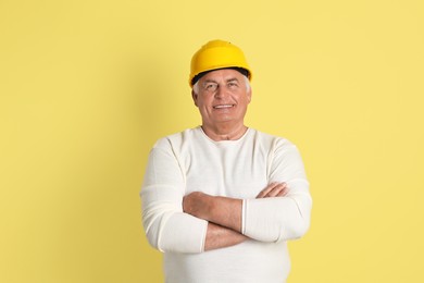 Photo of Engineer in hard hat on yellow background