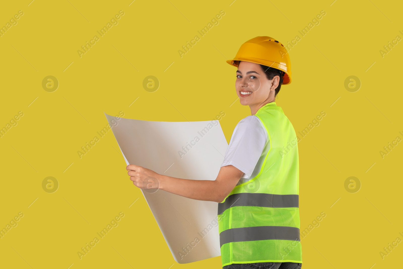 Photo of Engineer in hard hat with draft on yellow background