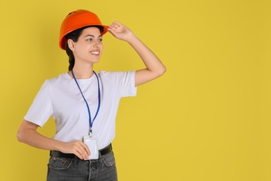 Photo of Engineer in hard hat on yellow background, space for text