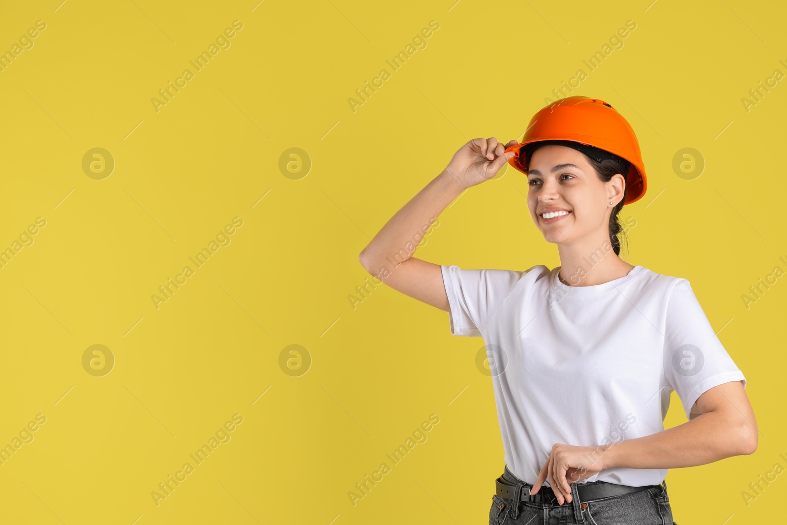 Photo of Engineer in hard hat on yellow background, space for text