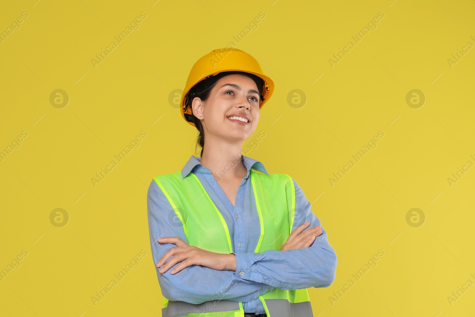 Photo of Engineer in hard hat on yellow background