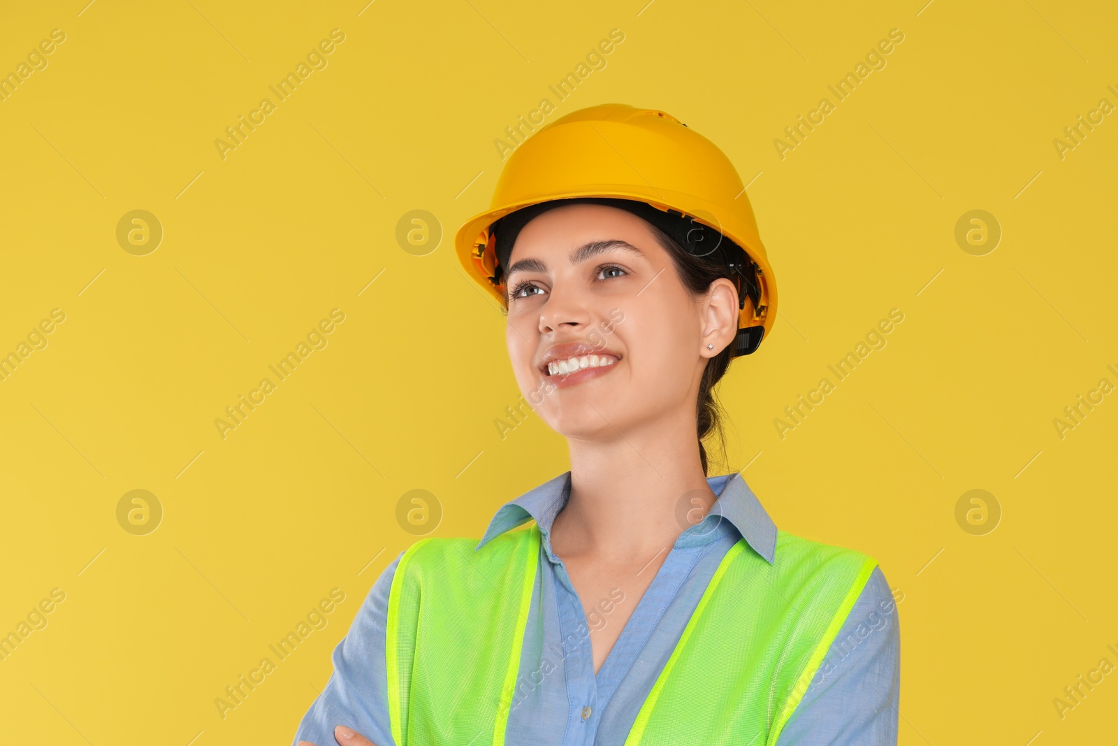 Photo of Engineer in hard hat on yellow background, space for text