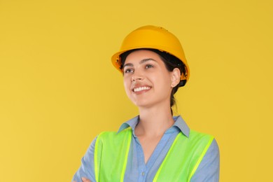 Photo of Engineer in hard hat on yellow background, space for text