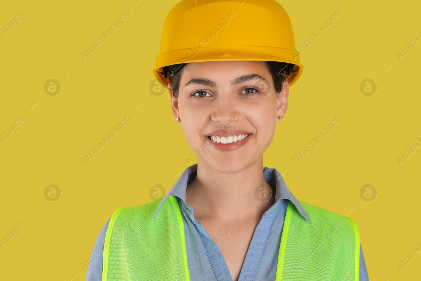 Photo of Engineer in hard hat on yellow background