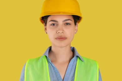 Photo of Engineer in hard hat on yellow background