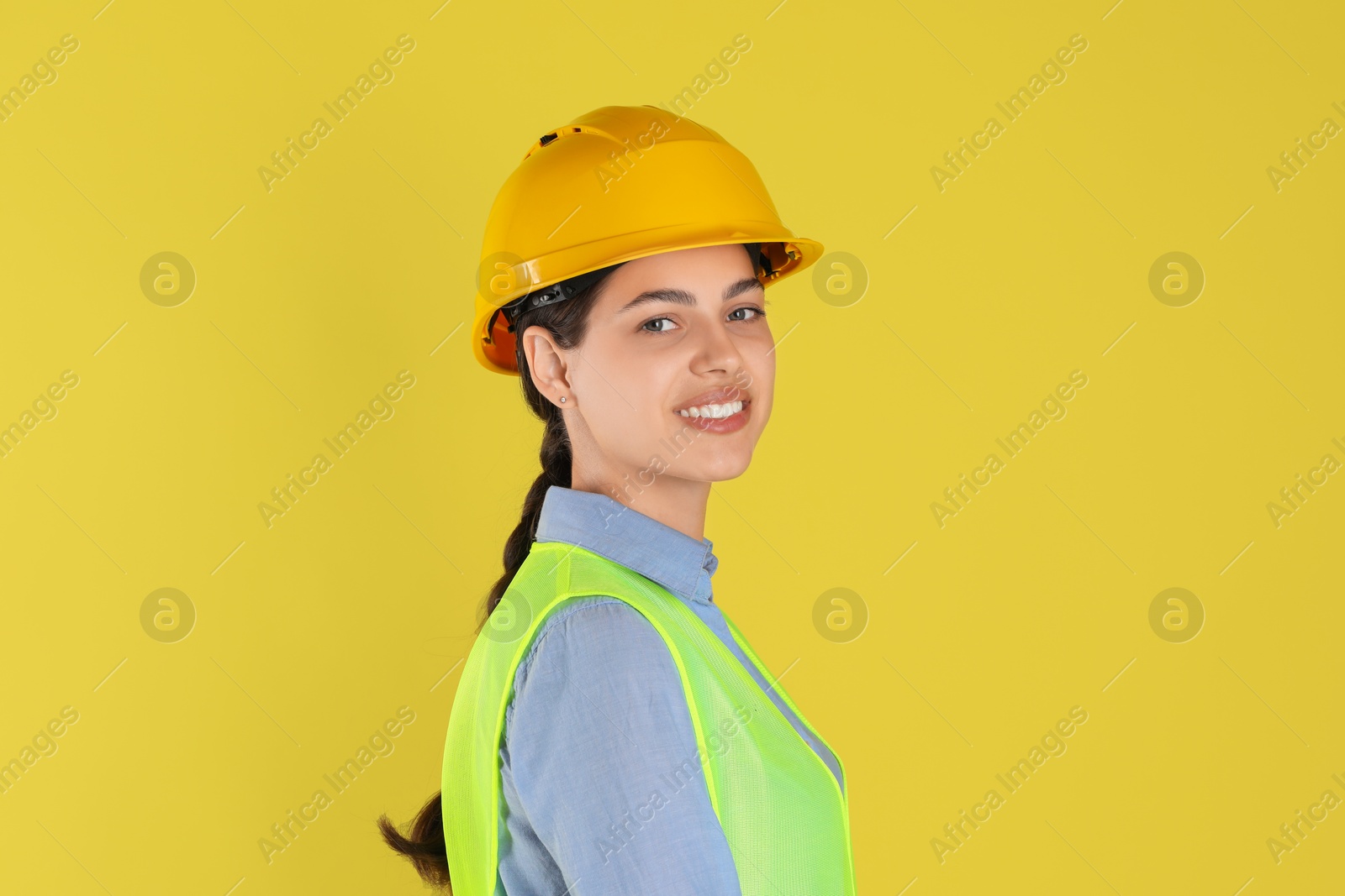 Photo of Engineer in hard hat on yellow background