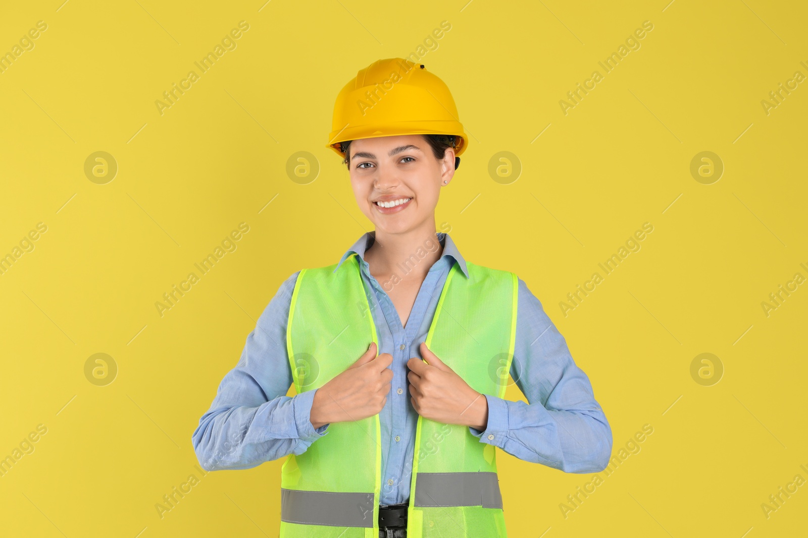 Photo of Engineer in hard hat on yellow background