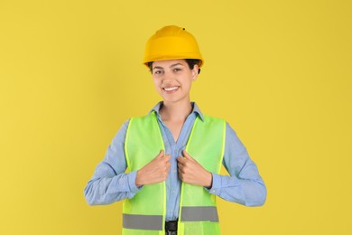 Engineer in hard hat on yellow background