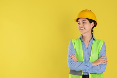 Photo of Engineer in hard hat on yellow background, space for text