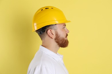 Engineer in hard hat on yellow background