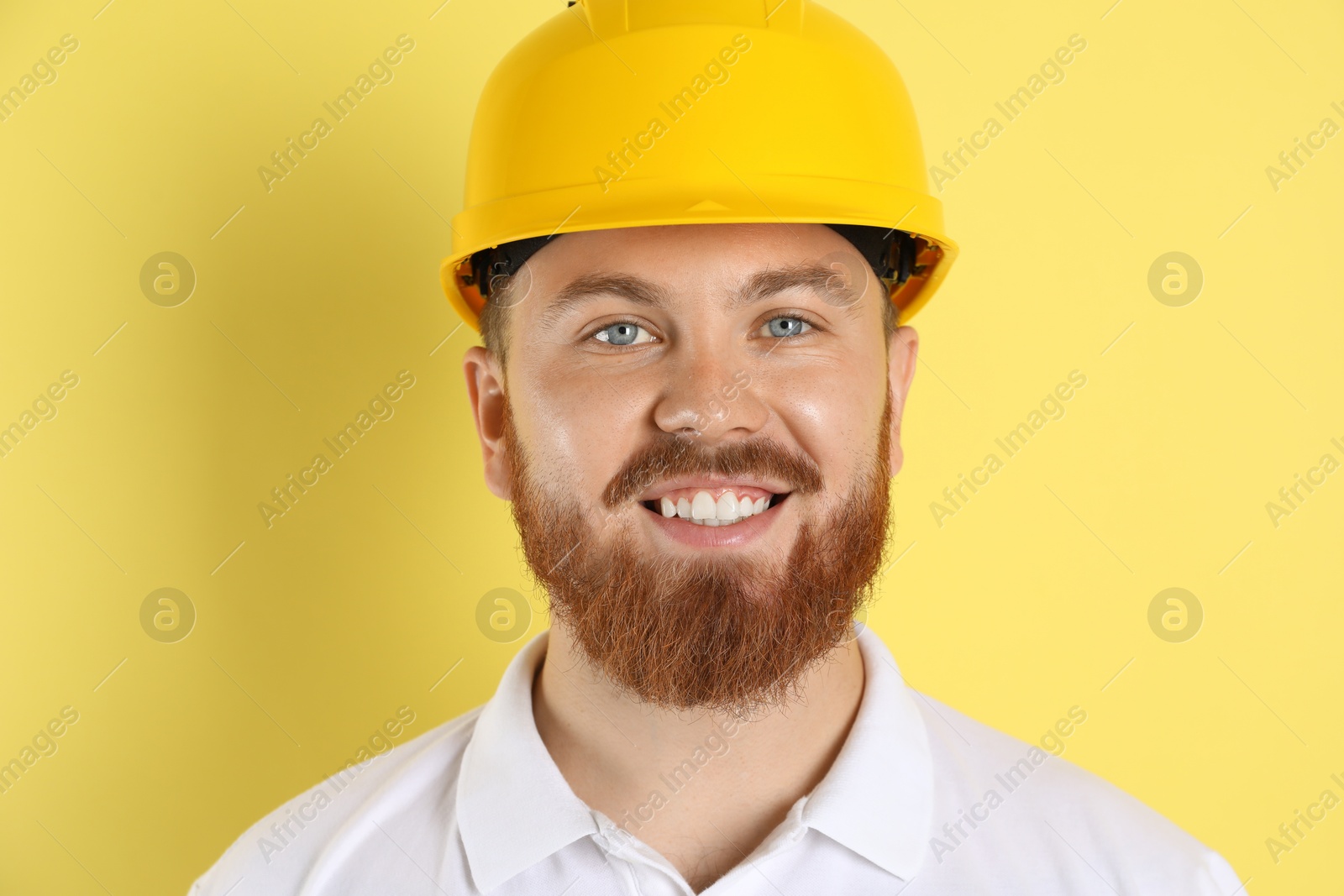 Photo of Engineer in hard hat on yellow background