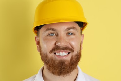 Photo of Engineer in hard hat on yellow background