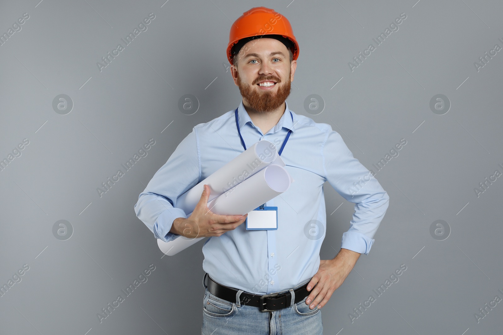 Photo of Engineer in hard hat with drafts on grey background