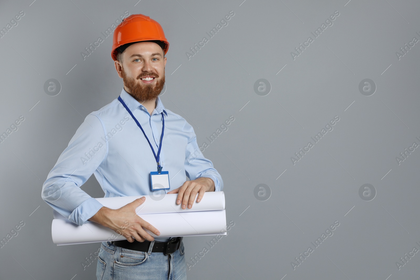 Photo of Engineer in hard hat with drafts on grey background, space for text