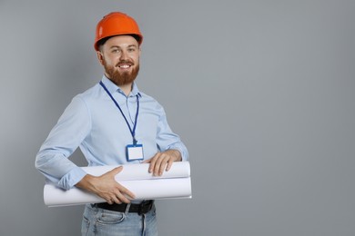 Engineer in hard hat with drafts on grey background, space for text